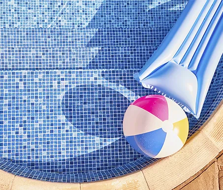 Aspirador manual e acessórios na borda da piscina