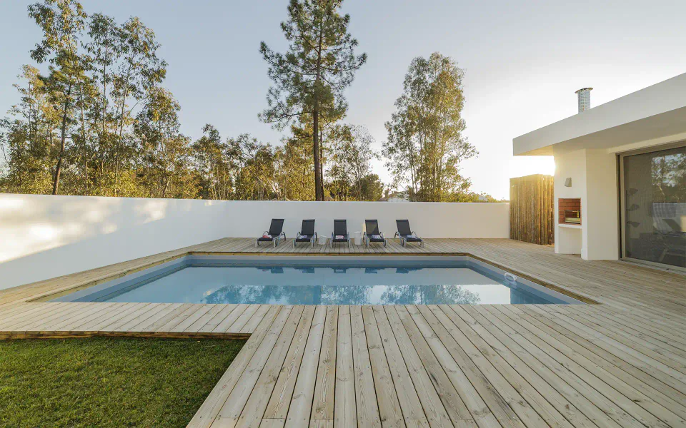 Imagem institucional de piscina residencial com deck