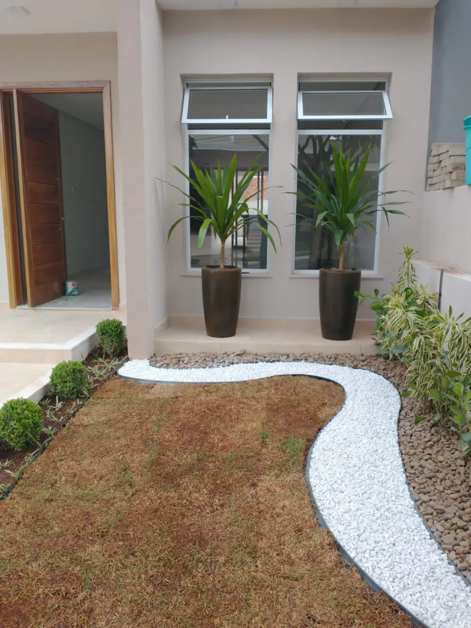Caminho de pedras em jardim residencial com folhagens
