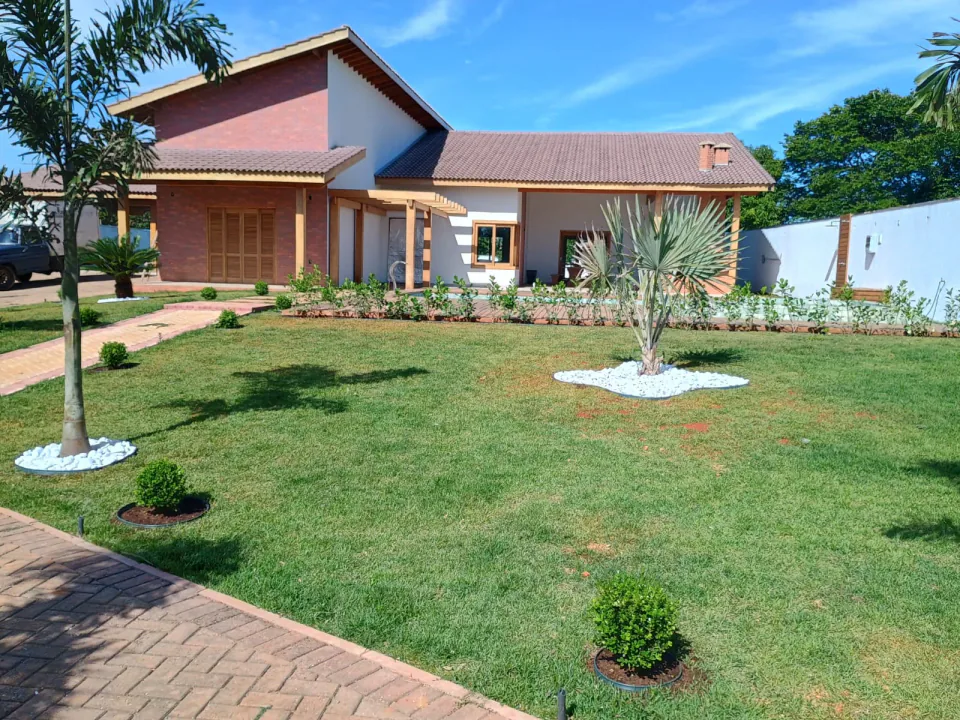 Jardim residencial com gramado, palmeiras e canteiros