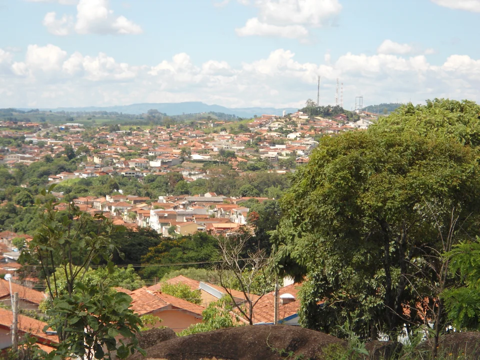 Vista de Espírito Santo do Pinhal, São Paulo, entre árvores e colinas.