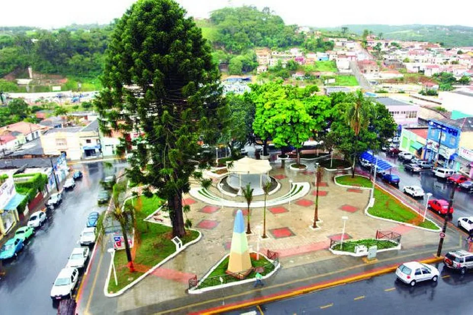 Praça arborizada de Piedade, com coreto, jardins e comércio ao redor