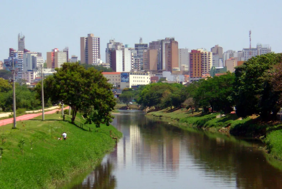 Rio Sorocaba, margens arborizadas e edifícios em Sorocaba, São Paulo.