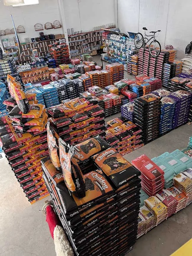 Interior da loja com sacos de ração organizados em pilhas