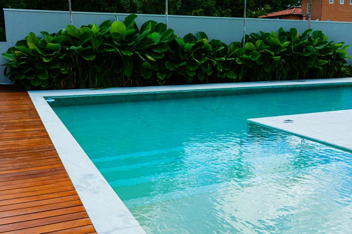 Detalhe da borda clara de uma piscina junto ao deck
