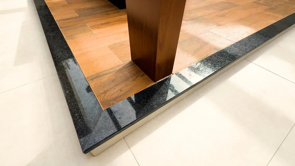 Detalhe do acabamento escuro junto ao piso e à porta