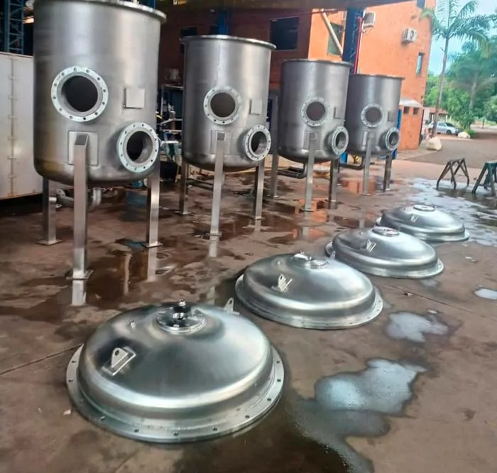 Tanques e tampas metálicas organizados na oficina