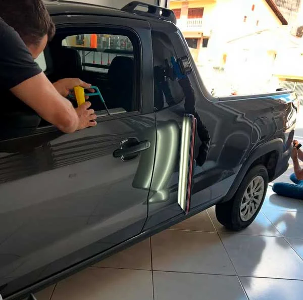 Trabalho na porta de uma picape dentro da oficina