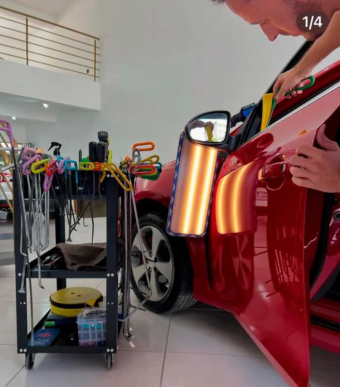 Lateral de automóvel vermelho sob iluminação de inspeção