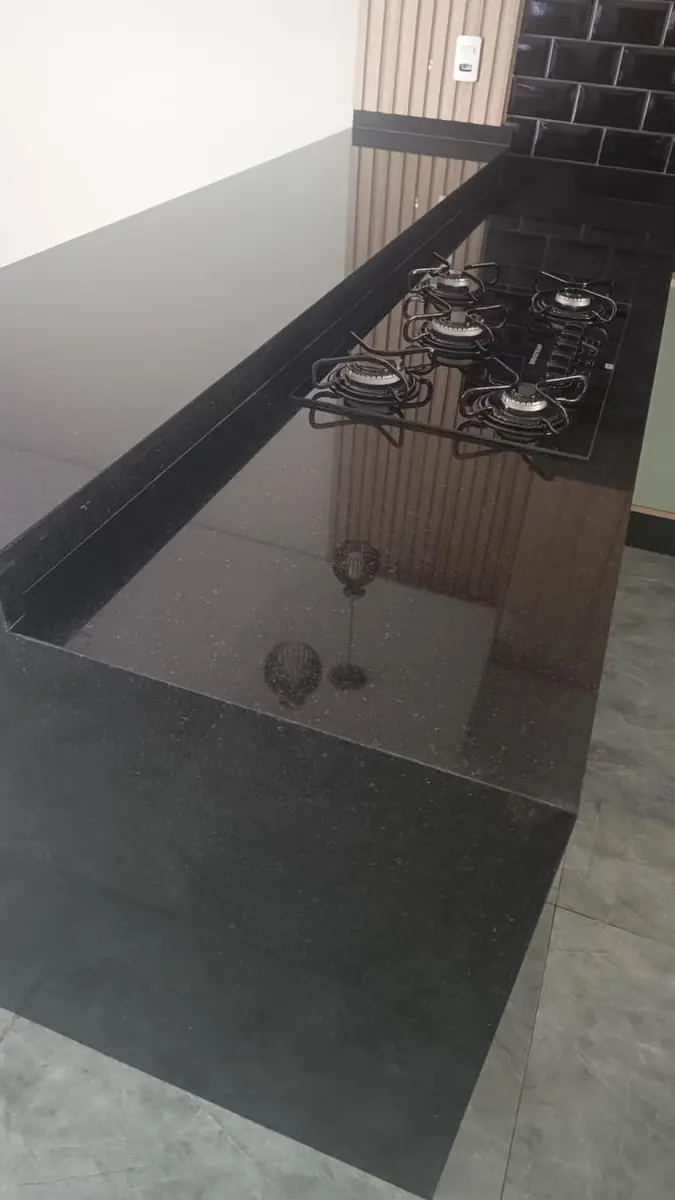 Vista superior de bancada escura polida com cooktop embutido
