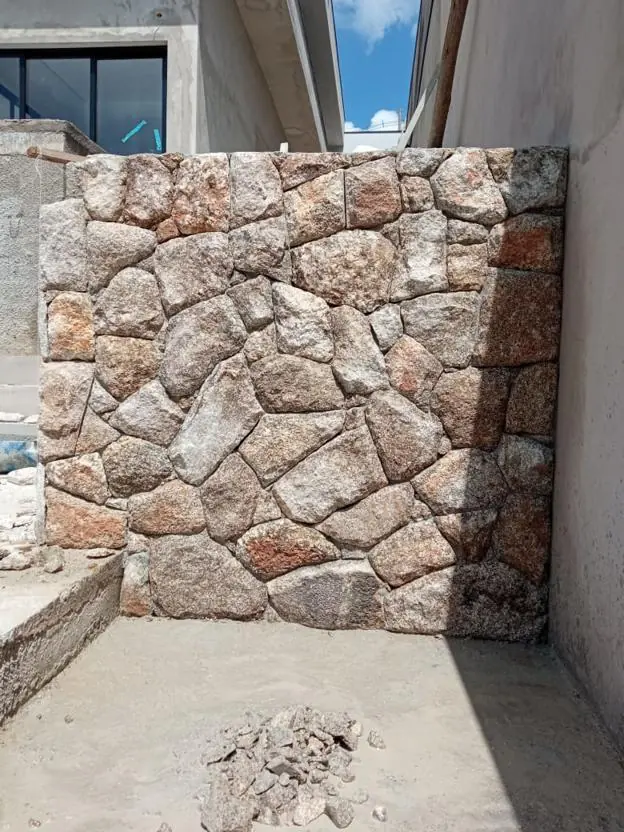 Muro revestido com pedras de tamanhos e tons variados