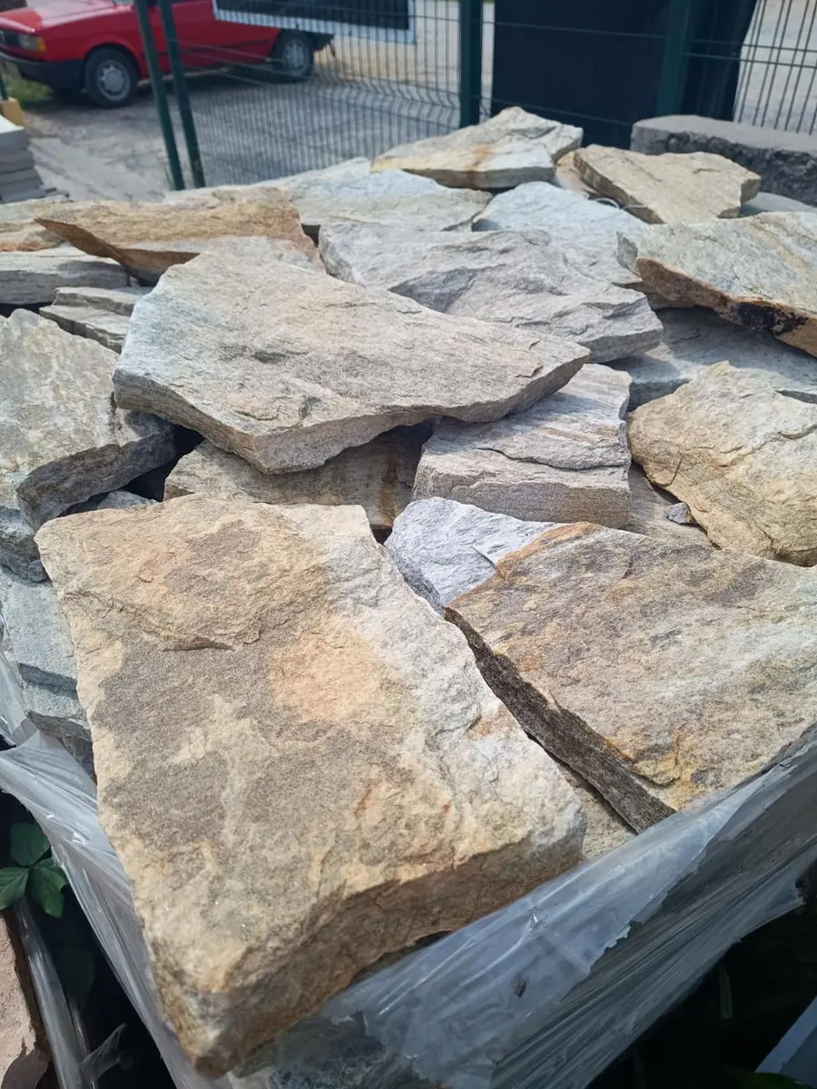 Peças irregulares de pedra natural empilhadas para revestimento