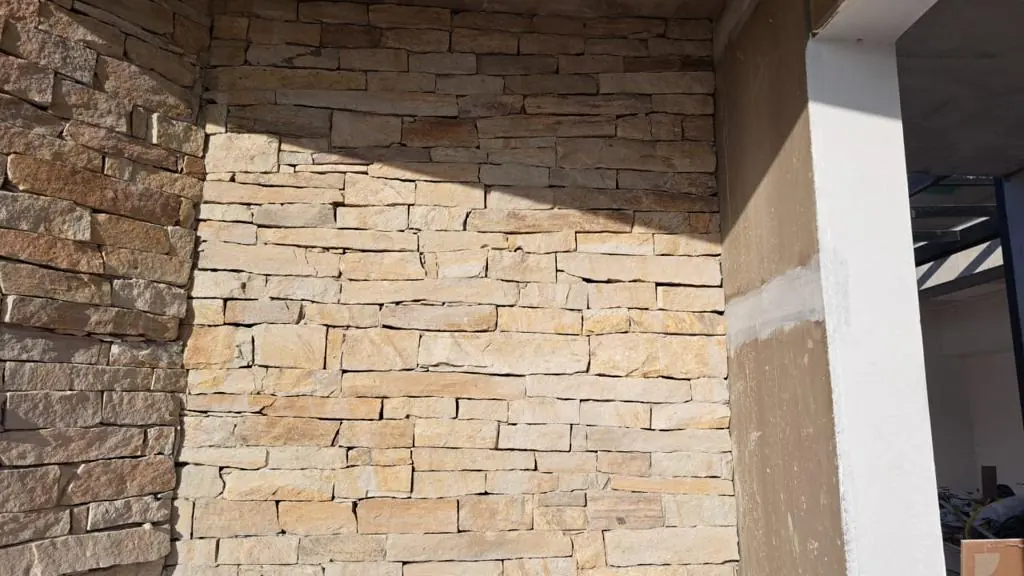 Parede revestida com filetes de pedra em tons bege